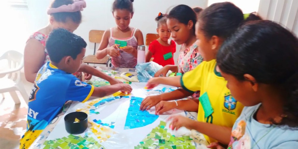 Crianças confeccionam bonés e painel da bandeira nacional a partir de recortes de revistas
